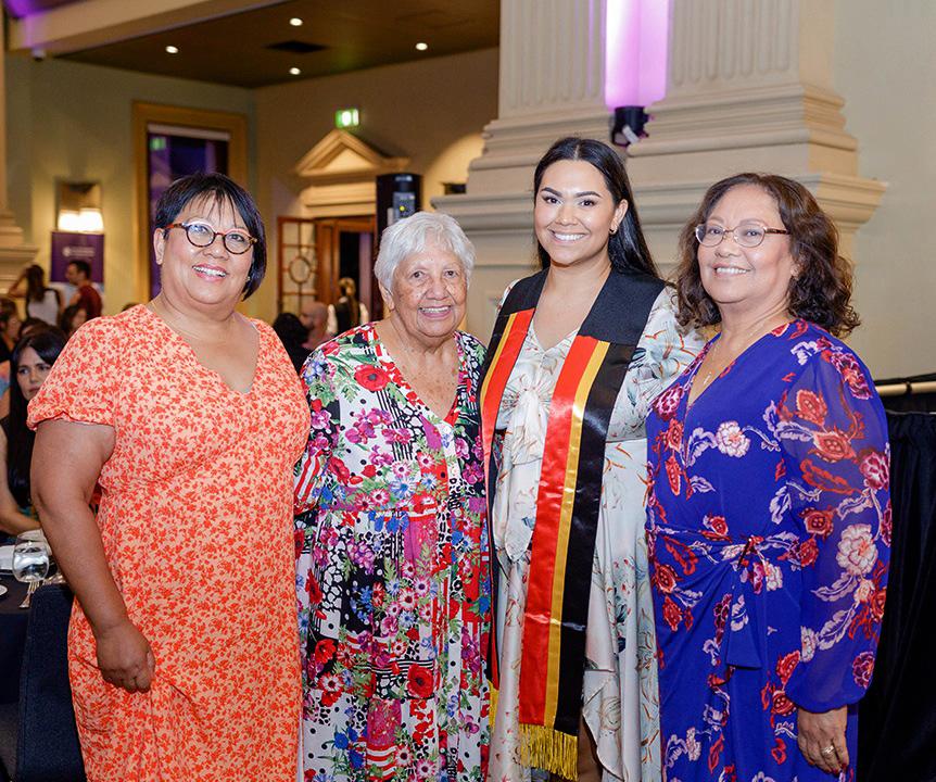 Three women beside a younger woman wearing a graduation sash