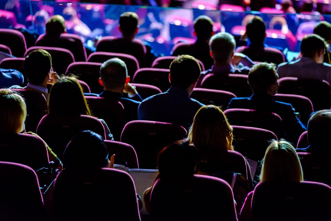 A crowd of people watching the stage during a conference.